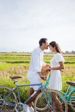 man kissing girlfriend on forehead in the street in the countryside. Romantic young man giving a kiss to his woman in the city street. Loving young couple