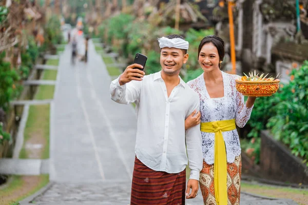 Lovely Balinese Couple Traditional Clothing Take Self Portrait Using Mobile — Zdjęcie stockowe
