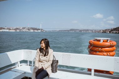 woman sitting on a ferry boat crossing the bosphorus