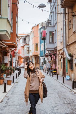 beautiful woman walking in balat turkey full of colorful house