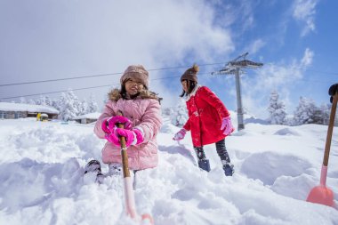 two girl playing with snow. asian little sister enjoy their time in snowy winter together