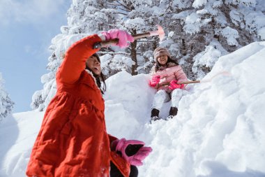 two girl playing with snow. asian little sister enjoy their time in snowy winter together