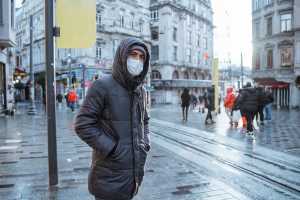 man wearing face mask waiting for the tram in the middle of the city in istanbul