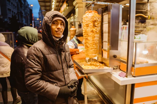 man waiting and ordering food at the kebab shop outside