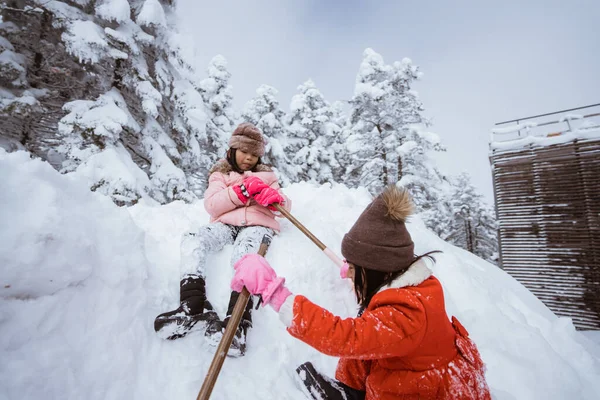 two girl playing with snow. asian little sister enjoy their time in snowy winter together