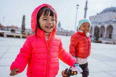happy kid running around the square in city centre of konya turkey with mosque in the background