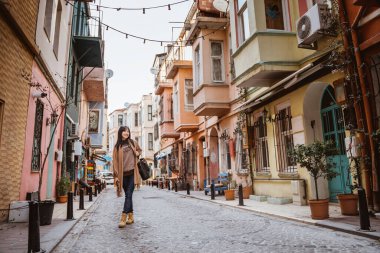 beautiful woman walking in balat turkey full of colorful house