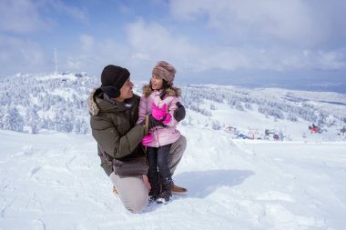 happy father and daughter in the snow enjoying their time on top of the uludag mountain