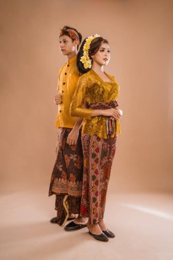 portrait of balinese couple with traditional costume over isolated background studio