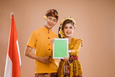 portrait of happy couple using tablet pc and showing to camera