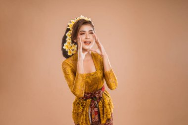 beautiful balinese woman with shouting gesture over isolated background