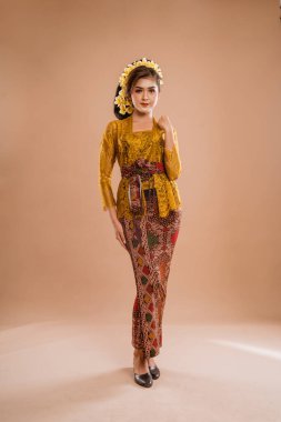 full body portrait of balinese woman wearing brown kebaya over isolated background