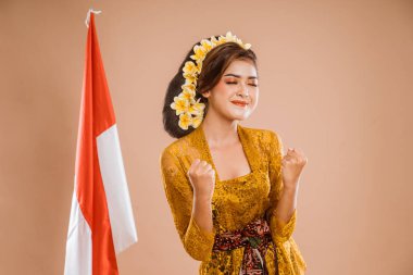 excited woman with balinese traditional kebaya costume over isolated background