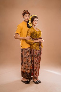portrait of balinese couple with traditional costume over isolated background studio