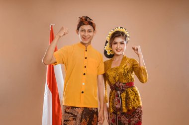 excited balinese couple with arm up looking at camera isolated background