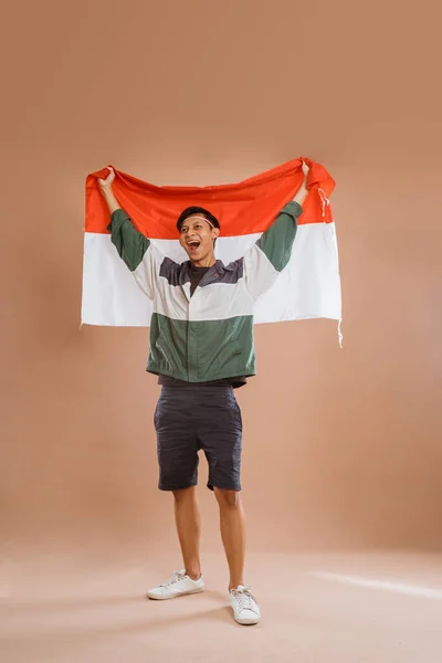 Excited Male Athelete Indonesia Holding Indonesian Flag Proudly Isolated Background — 스톡 사진