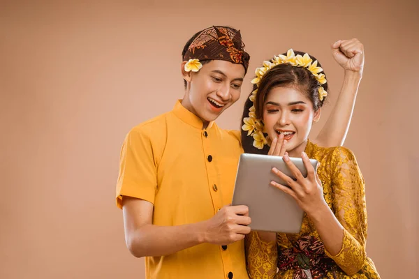 Excited Balinese Couple Using Tablet Together Isolated Background — Zdjęcie stockowe