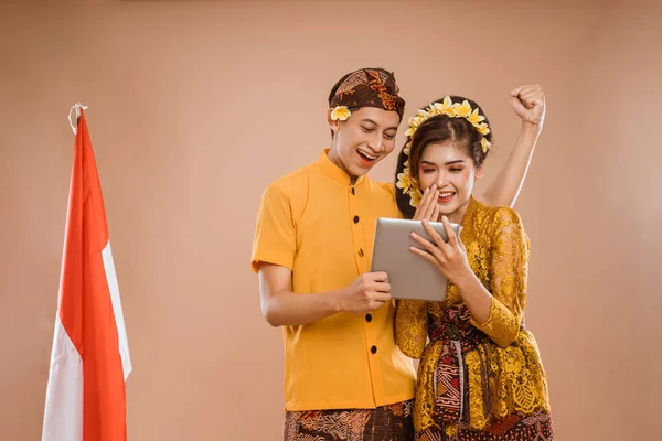 Excited Balinese Couple Using Tablet Together Isolated Background — ストック写真