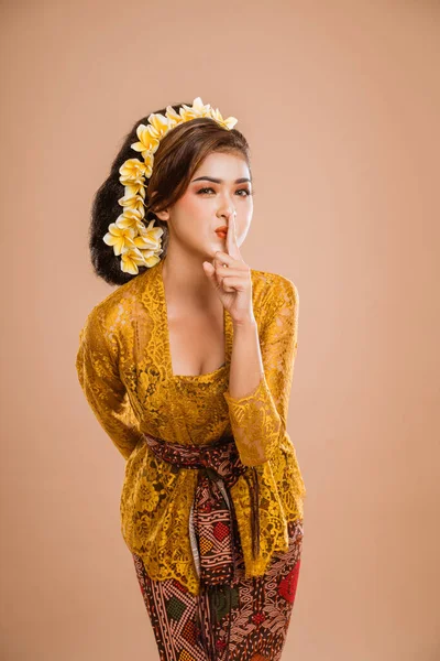 balinese woman with kebaya showing be quiet gesture. concept of bali day of silence