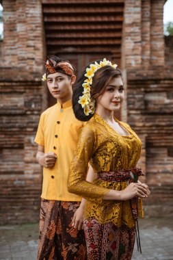 portrait of beautiful balinese couple portrait in front of the pura gate