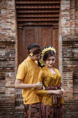 portrait of beautiful balinese couple portrait in front of the pura gate