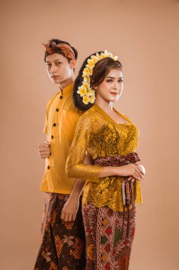 portrait of balinese couple with traditional costume over isolated background studio