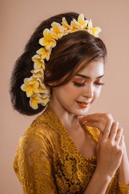 beauty portrait of beautiful balinese woman in kebaya isolated over brown background