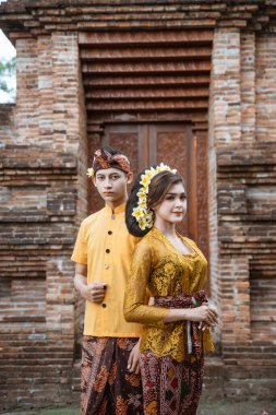 portrait of beautiful balinese couple portrait in front of the pura gate