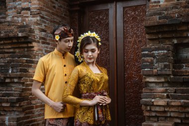 portrait of beautiful balinese couple portrait in front of the pura gate