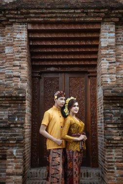 portrait of beautiful balinese couple portrait in front of the pura gate
