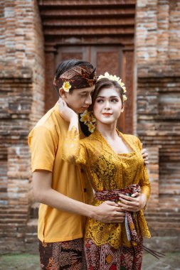 portrait of beautiful balinese couple portrait in front of the pura gate