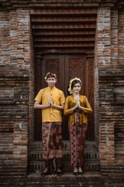 portrait of beautiful balinese couple portrait in front of the pura gate