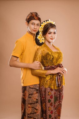 portrait of balinese couple with traditional costume over isolated background studio