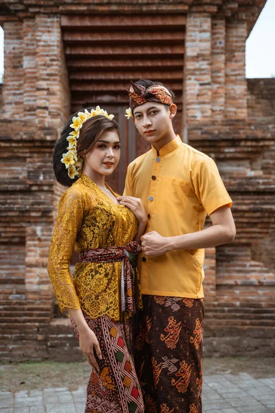 portrait of beautiful balinese couple portrait in front of the pura gate