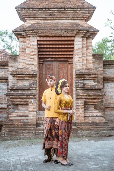 portrait of beautiful balinese couple portrait in front of the pura gate