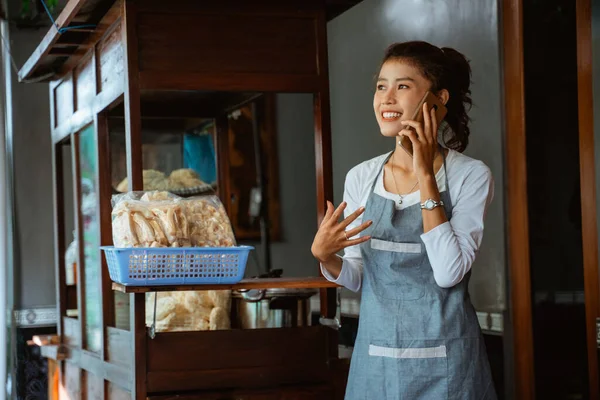 Female Chicken Noodle Seller Apron Making Phone Call Using Mobile — Stock fotografie