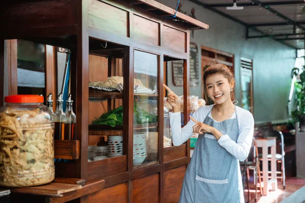 Female Chicken Noodle Seller Apron Smiling Pointing Finger Standing Front — Fotografia de Stock