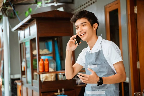 Male Chicken Noodle Seller Wearing Apron Makes Call Using Mobile — Stockfoto