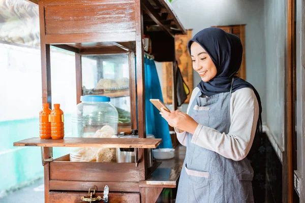 Woman Wearing Veil Wearing Apron Using Cellphone While Selling Chicken — Stock fotografie