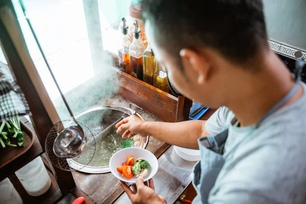 close up of the seller prepares the vegetables on the bowl on the cart