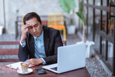 frustrated young businessman while working with his laptop outdoor