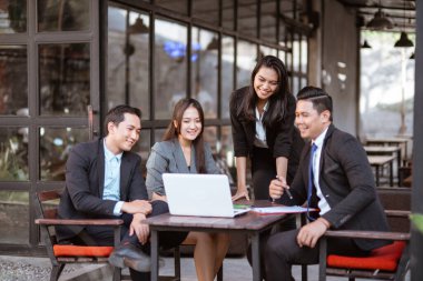 happy business people having a relaxed meeting with team in a coffee shop together