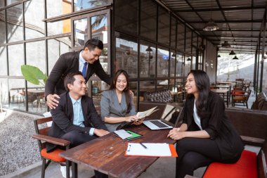 happy asian worker while taking a break during meeting in cafe. business partner and team discussion