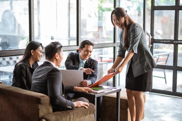 beautiful female worker showing some report during business partner meeting at cafe