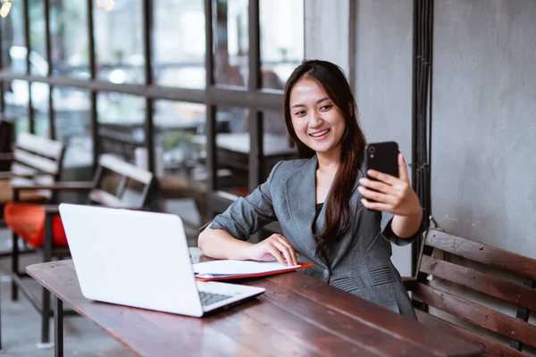 Beautiful Asian Businesswoman Having Video Conference Using Smartphone While Working — 스톡 사진