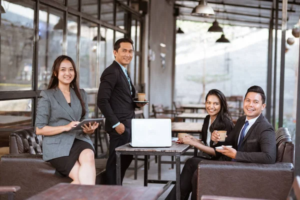 portrait of business asian partner smiling to camera while enjoying coffee together