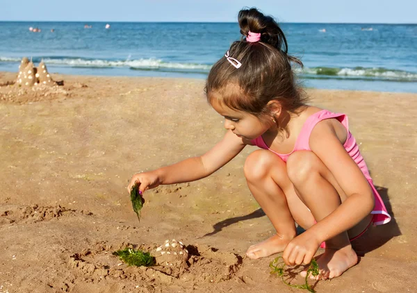 Liten flicka som leker vid havet — Stockfoto