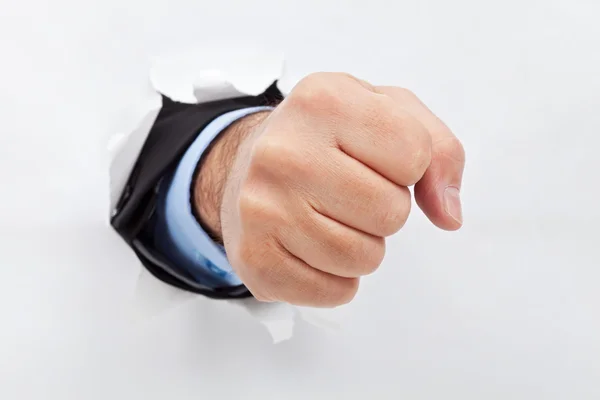 Businessman fist through the paper — Stock Photo, Image