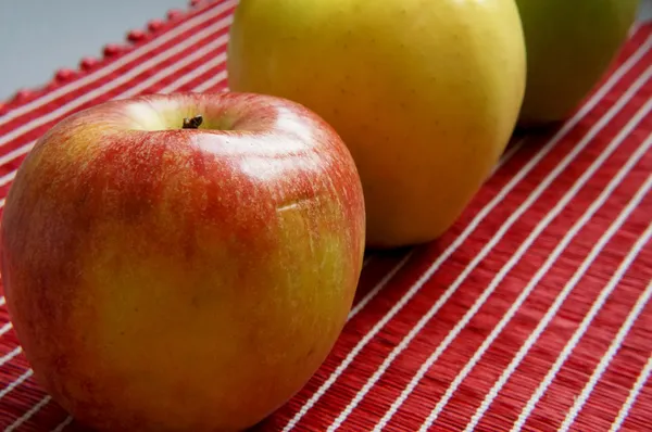 Barevné jablka na červené běžec — Stock fotografie