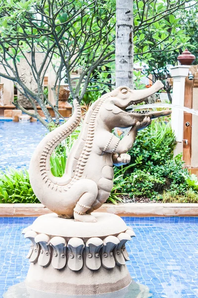 Crocodile statue spray water decorated blue pool — Stock Photo, Image
